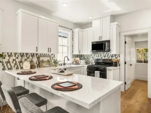 kitchen with white cabinets, a marble island, and gray bar stools