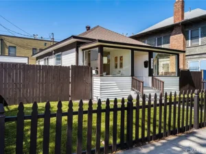 real estate white house with a brown roof and enclosed porch