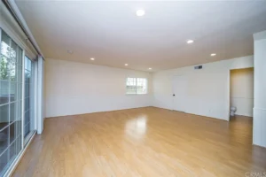 empty room with light wooden floors and soft beige walls.