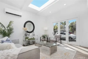 living room with large window doors, and light decor.