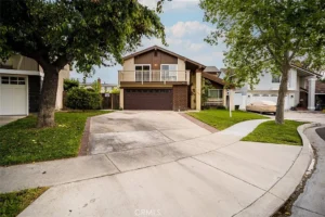 real estate two-story house with a brown garage and balcony