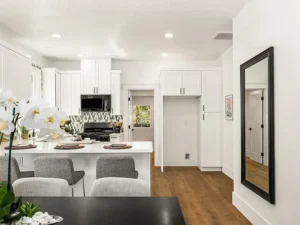Modern kitchen with white cabinets and polished wood floor