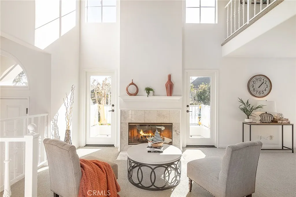 living room with high ceilings, featuring a lit fireplace between two tall windows