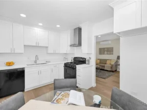 kitchen with white cabinets, black appliances, and wood floors
