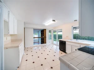 kitchen with white cabinets, tiled countertops, and a black dishwasher