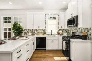 kitchen with white cabinetr, black appliances, and a patterned tile