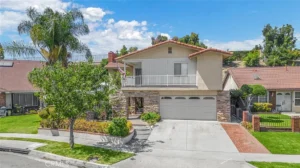 two-story real estate house with a beige facade and red-tiled roof