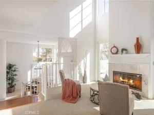 living room with high ceilings, fireplace and chair