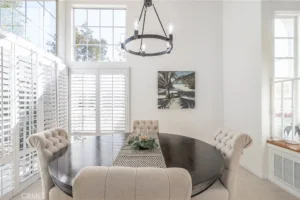 dining room with high ceilings and large windows with white shutters