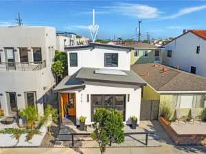real estate two-story white house with a flat roof, large windows, and a small garden in front