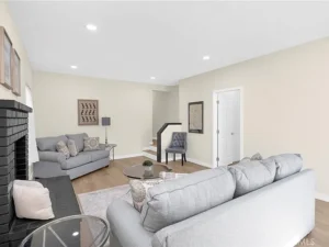 living room with beige walls, featuring two gray sofas and a matching armchair