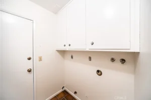 Laundry room with white walls and cabinets