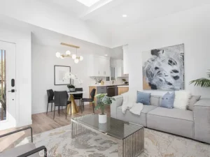 living room with a gray sofa with pillows and a throw and glass coffee table
