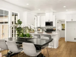 kitchen-dining area with a black table, gray chairs, and a large plant centerpiece
