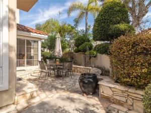 patio with a stone surface, table, chairs, and large umbrella