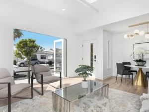 living room with open glass doors, chairs and glass coffee table with a plant