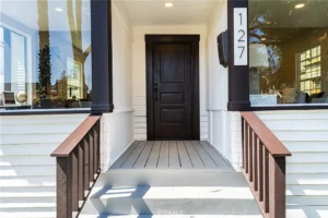 Front porch of a house with white siding and brown trim