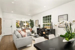 living room with gray sofa, pink cushions, black coffee table, and large window
