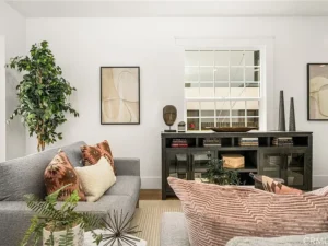 living room with gray sofa, patterned pillows, and abstract wall art