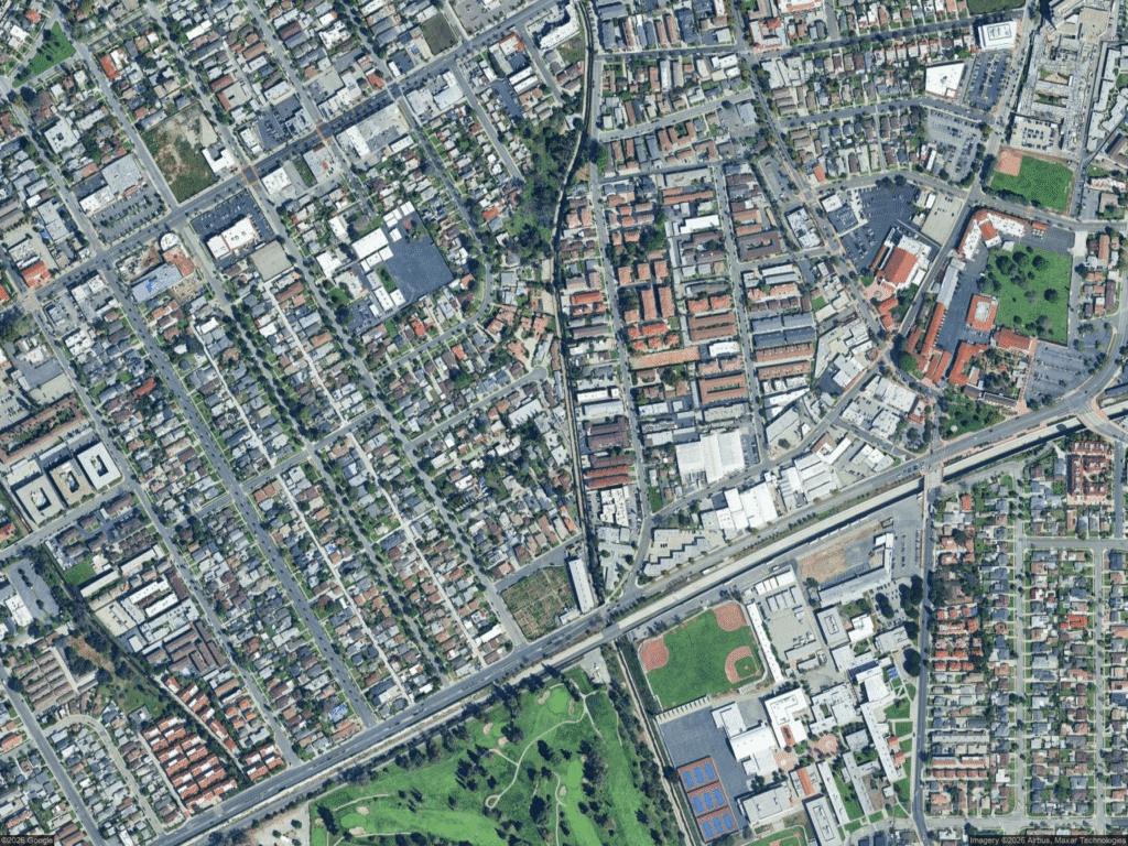 Aerial view of a dense urban area with a grid of streets and residential buildings.